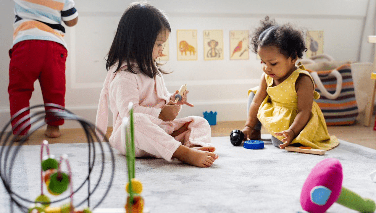 A group of children playing with toys in a playroom.